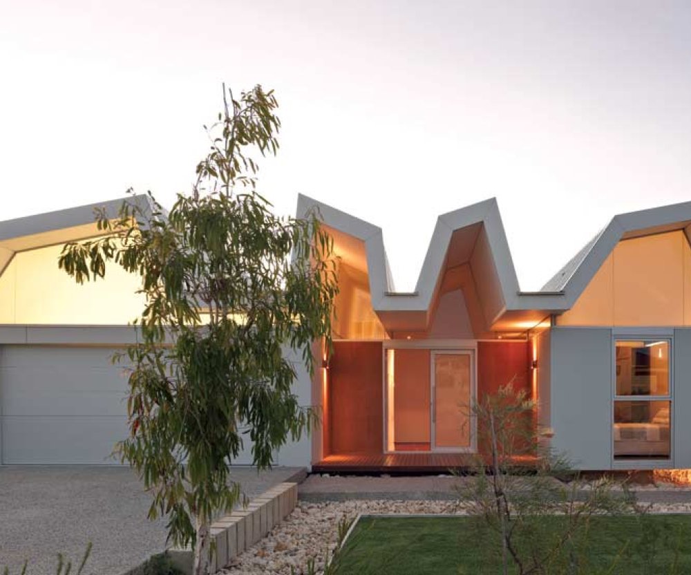 From the street, one can observe the composition of hovering platform, ribbons of glass and vaulted roof bays, which combine to set this house apart from its neighbours.