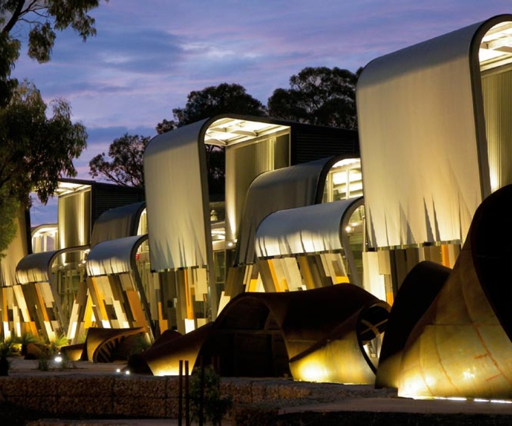 Apart from the remarkable facade, what gives the building character is the surging, undulating roofscape of split, curved roofs in three colours. 